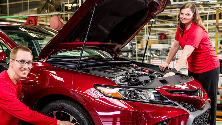 Two associates working together on a Camry on the production line